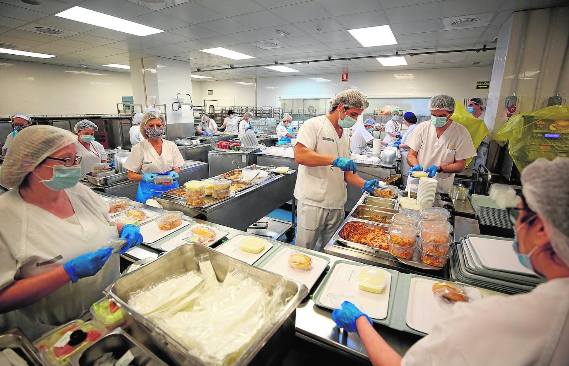 Cocina. Un momento del proceso de emplatado del cerca de millar de menús que se sirven para la comida de todos los pacientes del hospital La Fe.