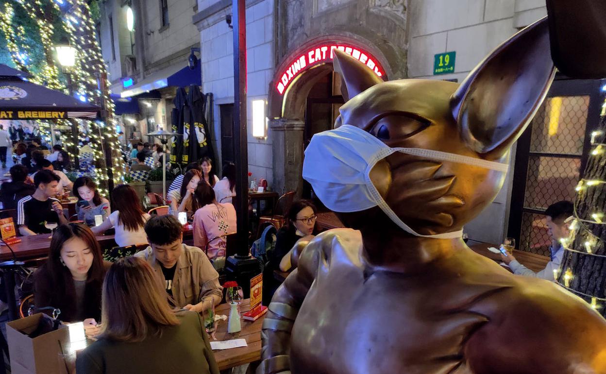 Una mascarilla colocada en el reclamo de un bar es el único rastro que recuerda la reciente epidemia.