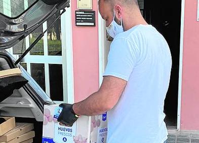 Imagen secundaria 1 - Dos clientes de Makro, ayer, en el aparcamiento de la empresa mayorista | Jorge Dasí saca de su coche los productos alimenticios que compró ayer para su pizzería de El Saler.