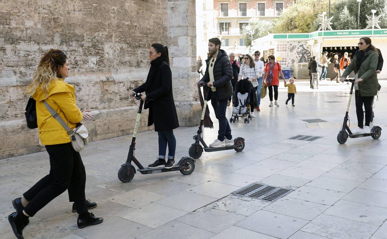 Varias personas circulan con patinete por Valencia