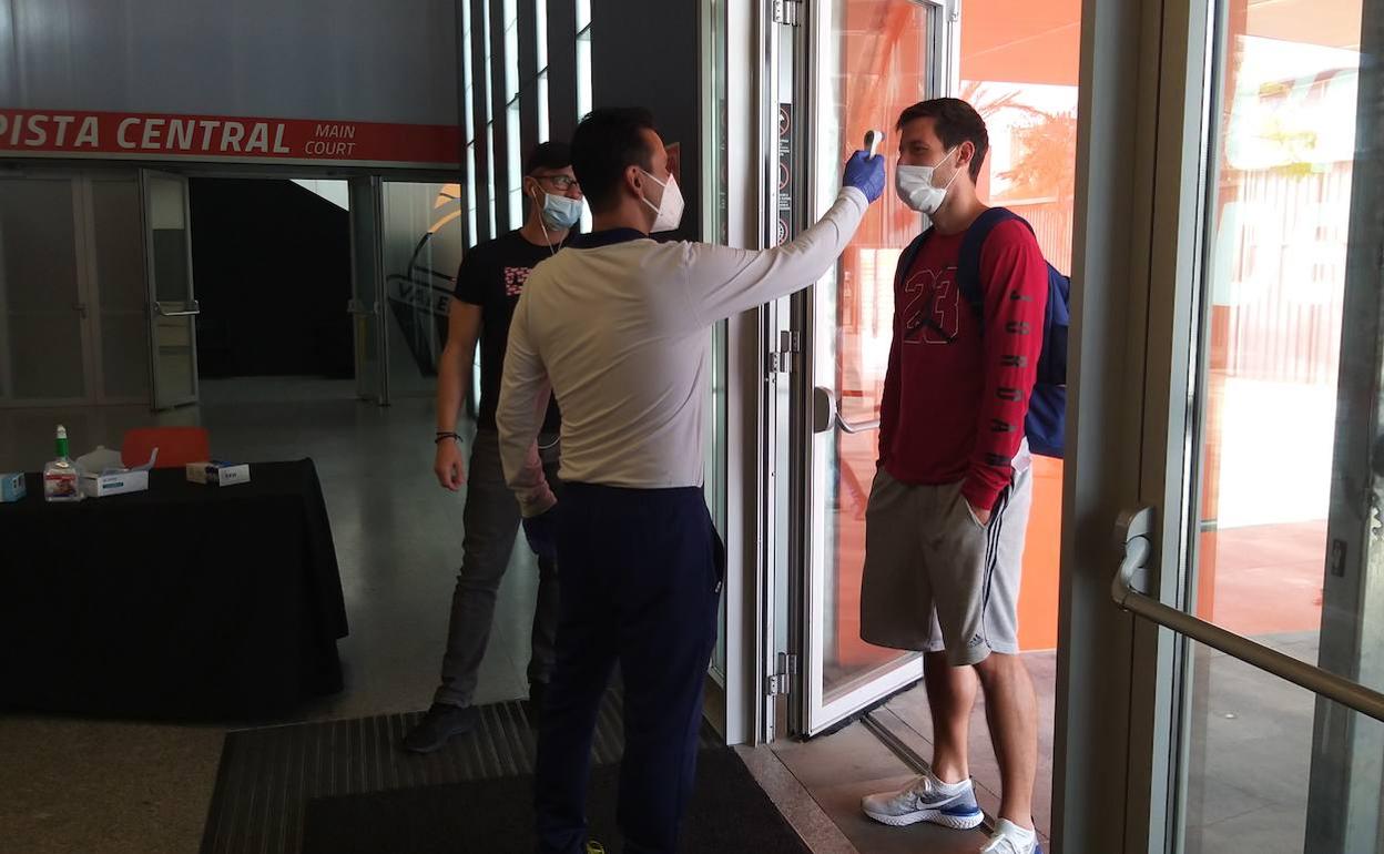 Van Rossom, junto al doctor Álvaro Sala, se somete el control de temperatura en la puerta de accesoa L'Alqueria.