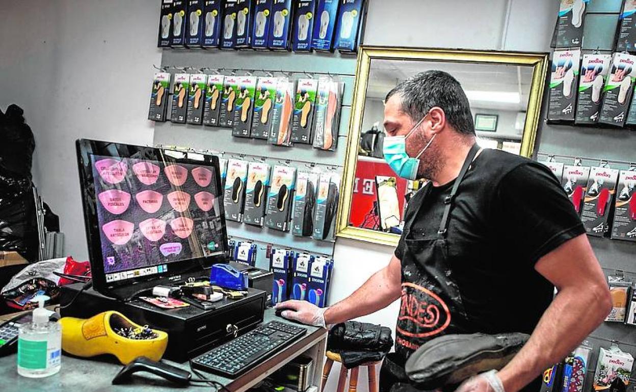 El dueño de un taller de calzado, en su negocio.