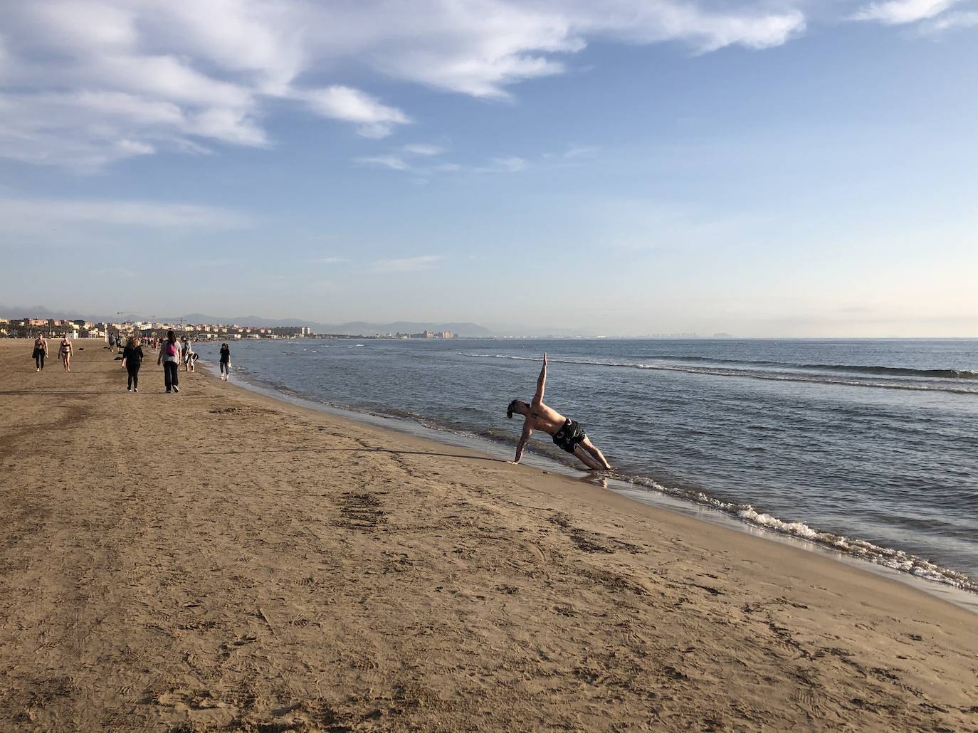 Nadadores, corredores, surfistas y personas practicando yoga se han dejado ver este jueves en las playas de Valencia desde que se ha asomado el sol, aprovechando las horas permitidas para practicar deporte en la ciudad. 