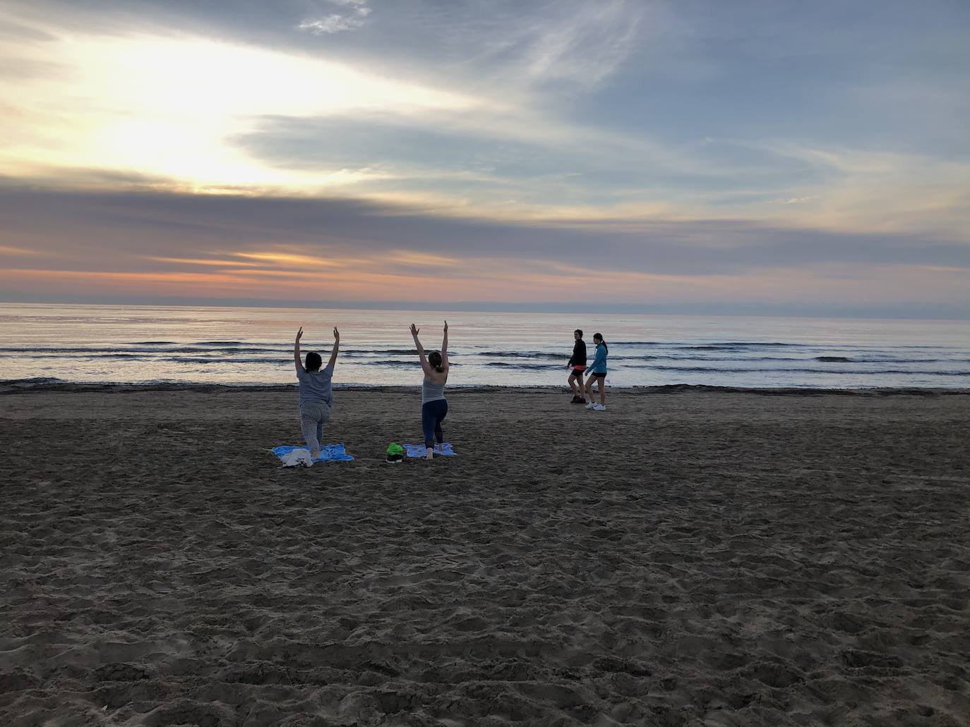 Nadadores, corredores, surfistas y personas practicando yoga se han dejado ver este jueves en las playas de Valencia desde que se ha asomado el sol, aprovechando las horas permitidas para practicar deporte en la ciudad. 