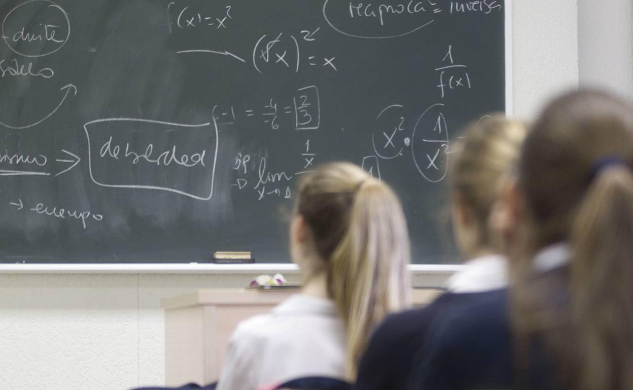 Unas alumnas atieneden en clase. 