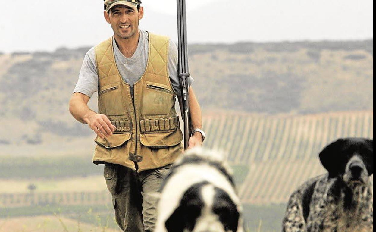 Un cazador camina junto a sus perros. 