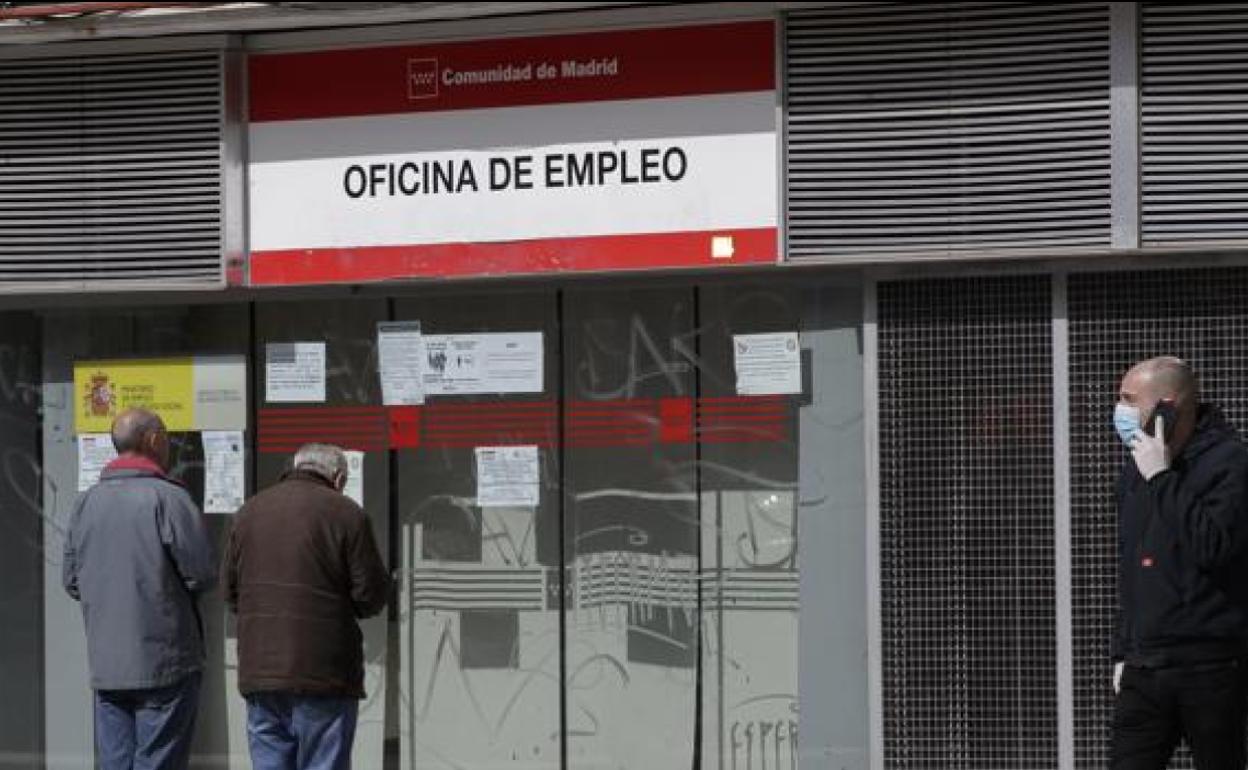 Varias personas con mascarilla a las puertas de una oficina del SEPE.