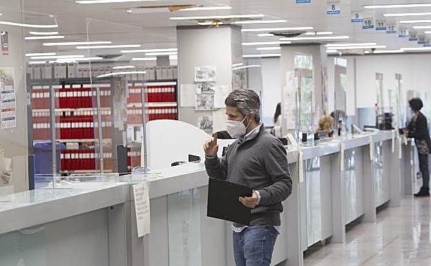 Imagen principal - El Registro Civil, plagado de mamparas de protección. Las sillas del zaguán, precintadas. Carteles marcan el aforo a la entrada de cada sala habilitada para celebrar juicios. 
