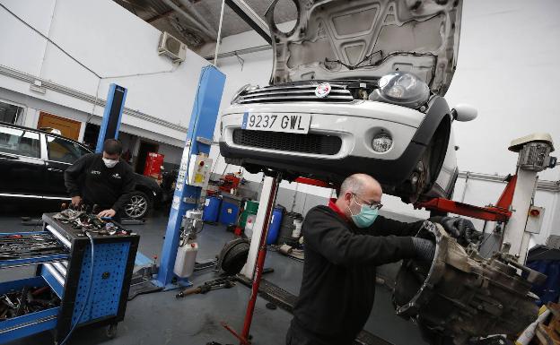Un trabajador en un taller de reparación de vehículos. 