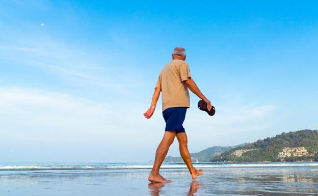 Un hombre pasea por la playa,