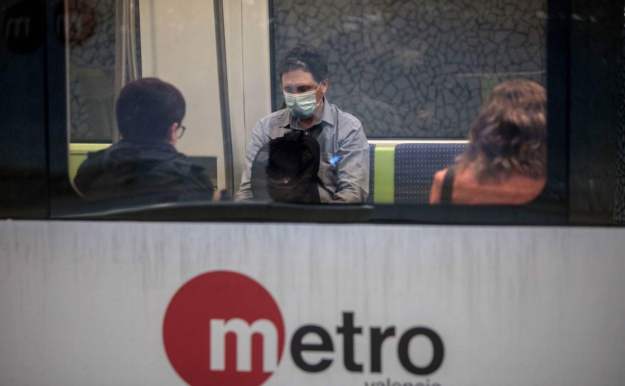 Un hombre se protege con una mascarilla en los vagones del metro. 