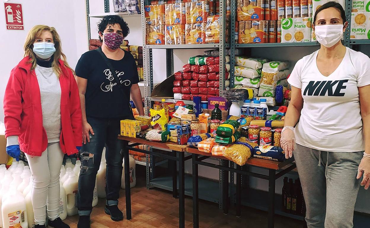 El personal de Cáritas Aldaia, junto con los lotes de alimentos. 