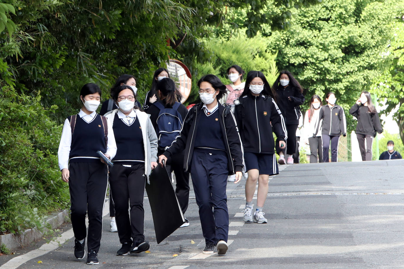 Corea del Sur, uno de los primeros países infectados por el coronavirus que surgió en la ciudad china de Wuhan, está recuperando poco a poco la normalidad. Muestra de ello ha sido el regreso a las clases de sus estudiantes. Los primeros en volver a los pupitres han sido los alumnos de bachillerato; el resto se irá incorporando poco a poco. No obstante, el inicio del curso escolar se ha hecho con una serie de medidas para evitar los contagios entre los estudiantes: el uso de mascarillas en todo momento, limpieza de los pupitres, ventilación continua de los cuartos, mámparas en el comedor y en las mesas y tomas de temperatura al entrar al colegio, todo ello, manteniendo las distancias de seguridad. 