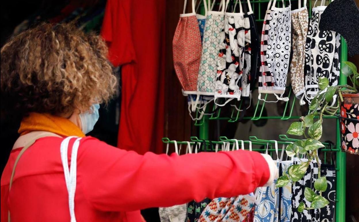 Una mujer mira las mascarillas a la venta en Valencia.