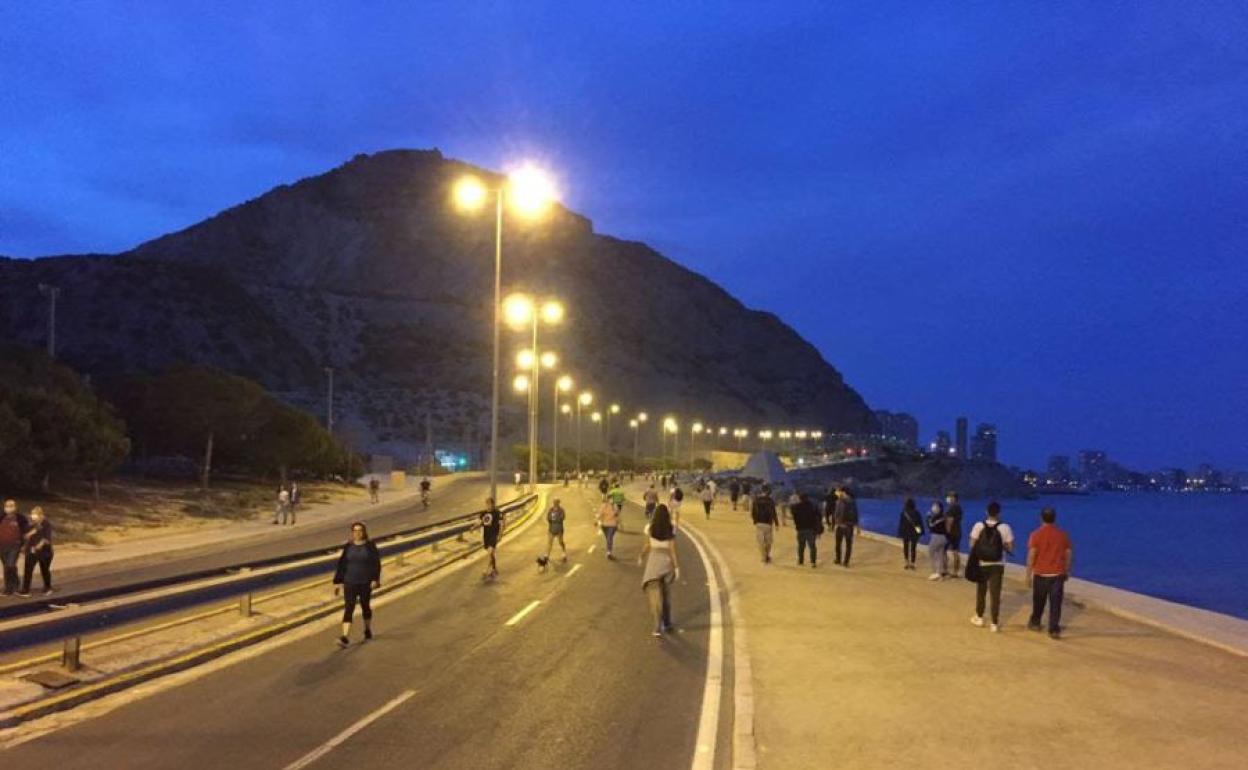 Personas paseando por la noche en Alicante.