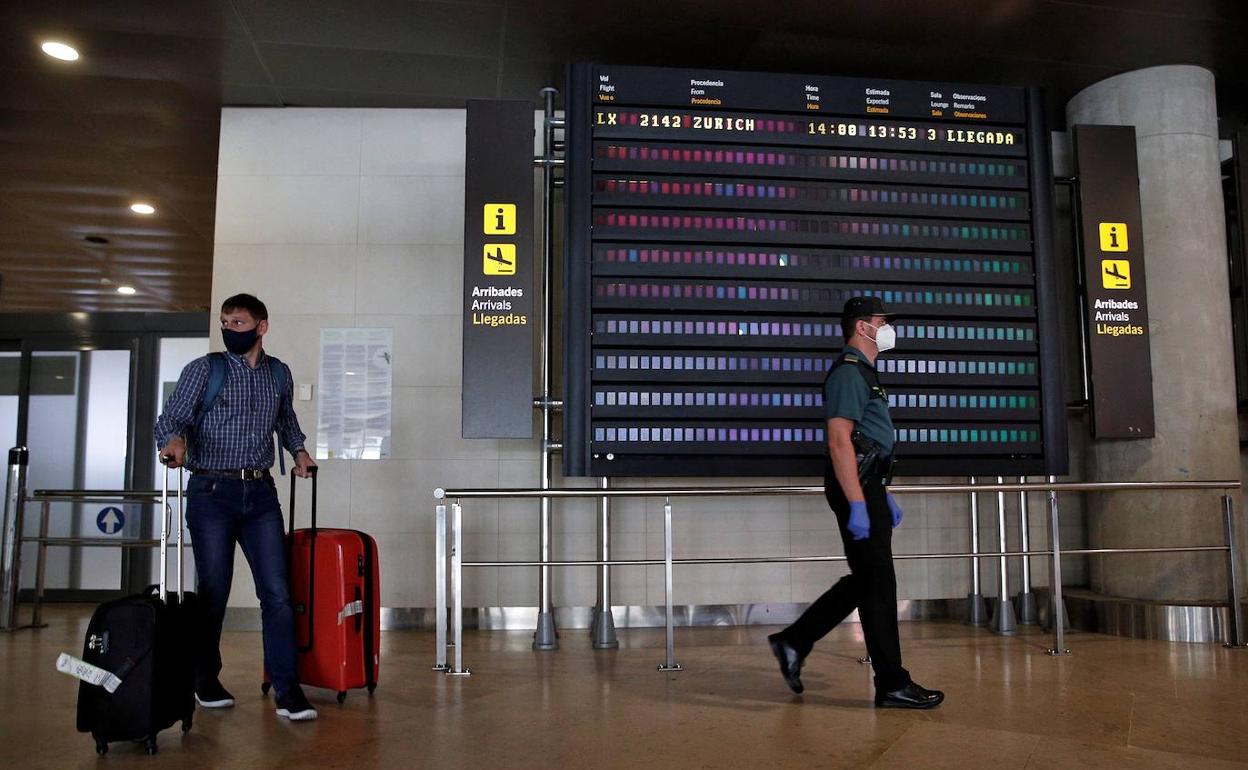 Un pasajero, con mascarilla, a su llegada al aeropuerto de Manises.