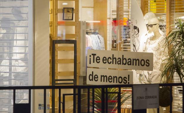 Preparativos para la reapertura de comercios en un centro comercial de Valencia.