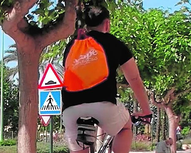Un ciclista por el carril bici de la población. 