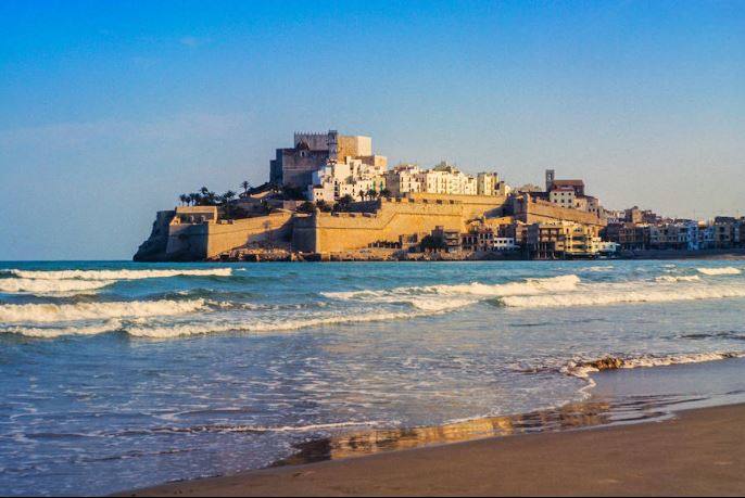 PLAYA PEÑÍSCOLA SUR (Peñíscola, Castellón) celebra este año su inclusión en el listado de banderas azules de la Comunitat. Se ubica al pie de las murallas y junto al puerto pesquero, con 300 m de longitud y 35 m de anchura de arena fina. Dispone de paseo marítimo, servicio de vigilancia y salvamento y de servicios básicos como son duchas e instalaciones con juegos infantiles y de voley-playa 