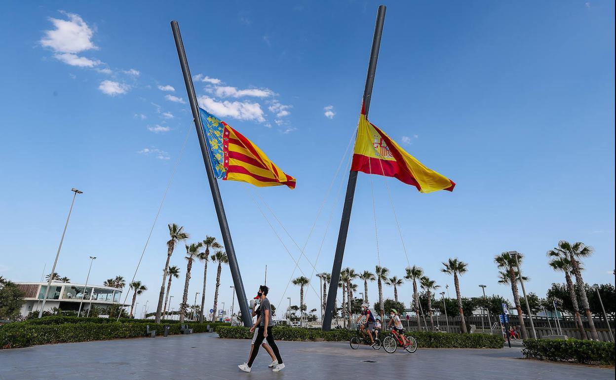 Varias personas pasean por Valencia con mascarilla.