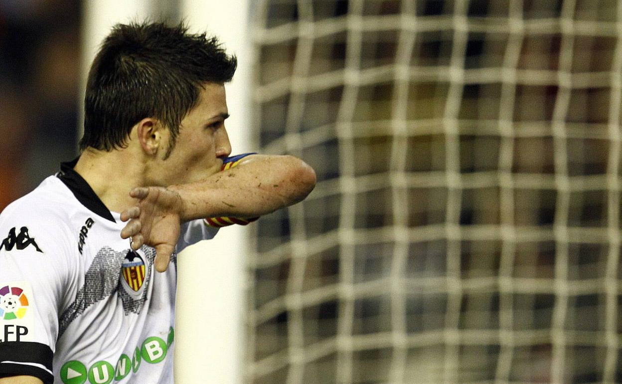 David Villa se besa el brazalete de capitán en la celebración de un gol con el Valencia. 