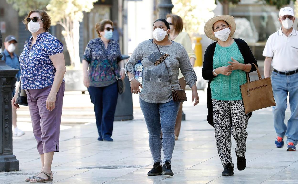 Varias personas se protegen con mascarilla en Valencia