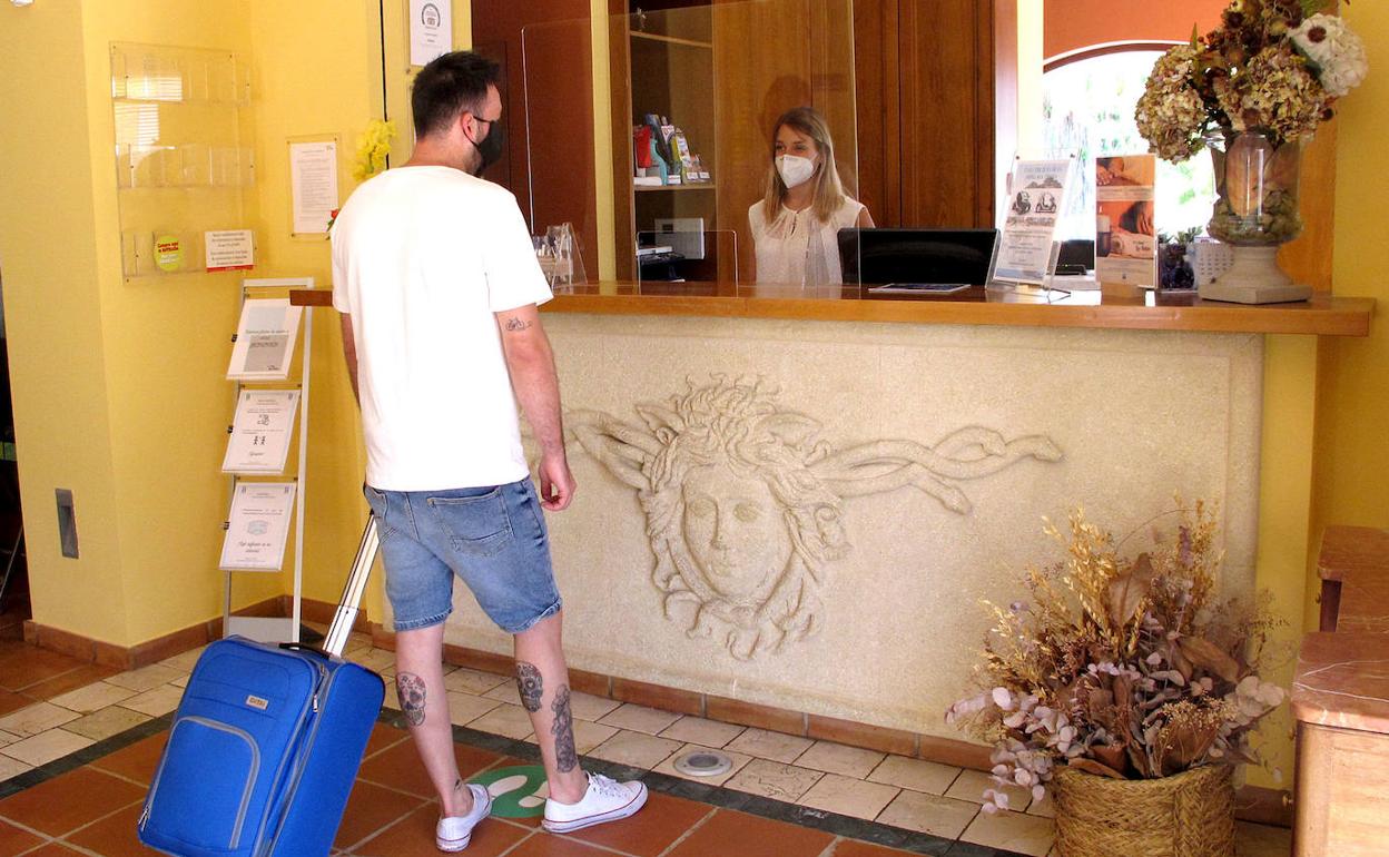 Un turista llega a la recepción del hotel Les Rotes. 