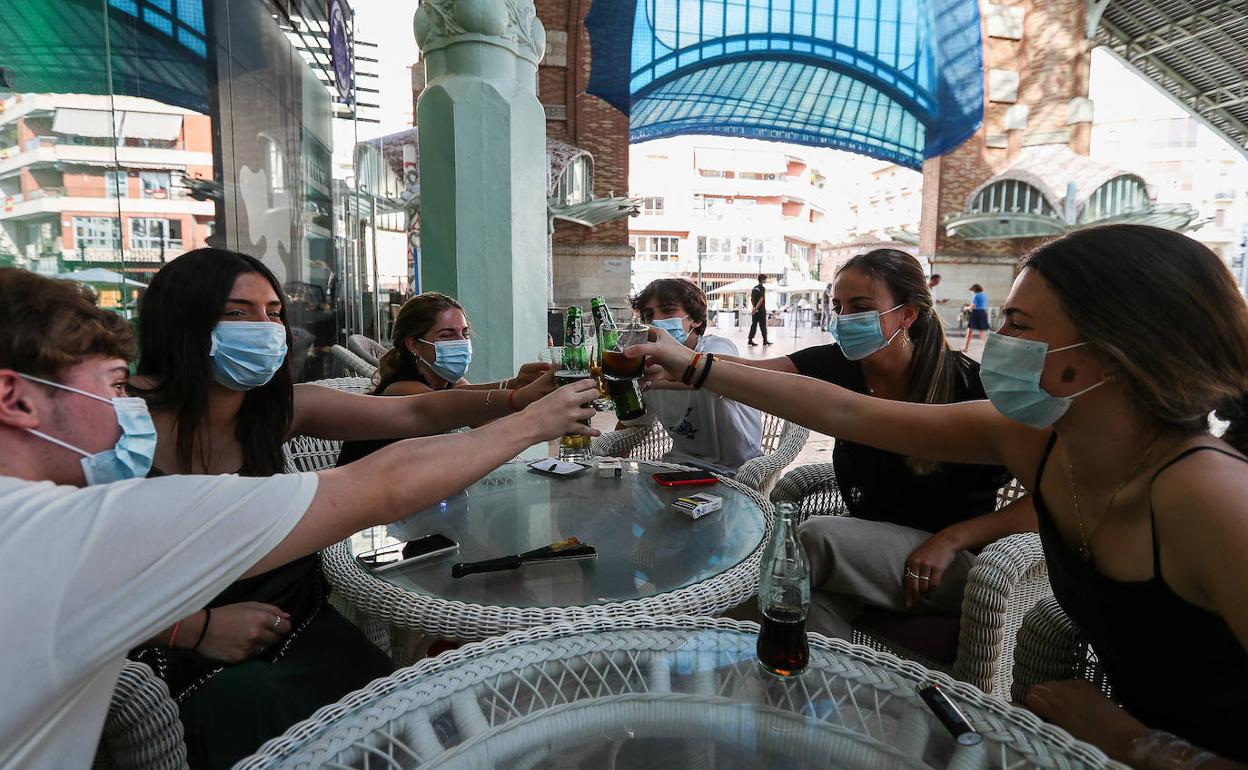 Un grupo de jóvenes brinda en una terraza de Valencia.