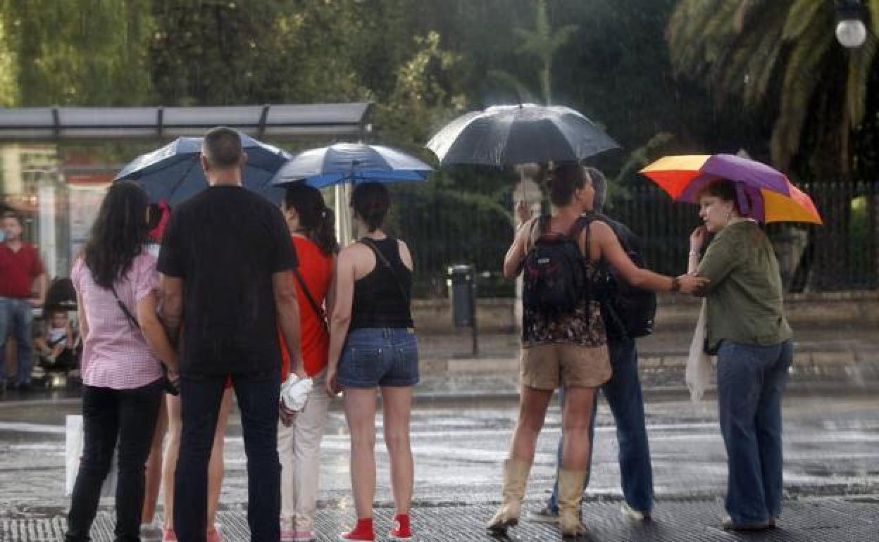 Varias personas con paraguas en Valencia.