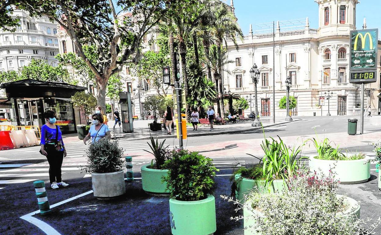 Delimitación en la plaza del Ayuntamiento del carril bus realizada con maceteros.