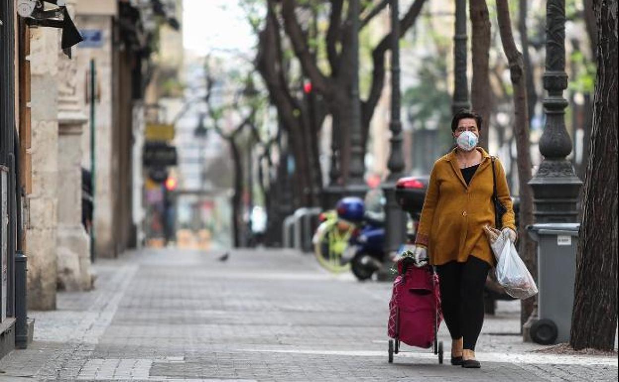 Una mujer se protege con una mascarilla.