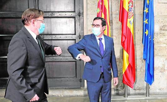 Ximo Puig saluda con el codo a Antonio Garamendi, en el Palau de la Generalitat. 