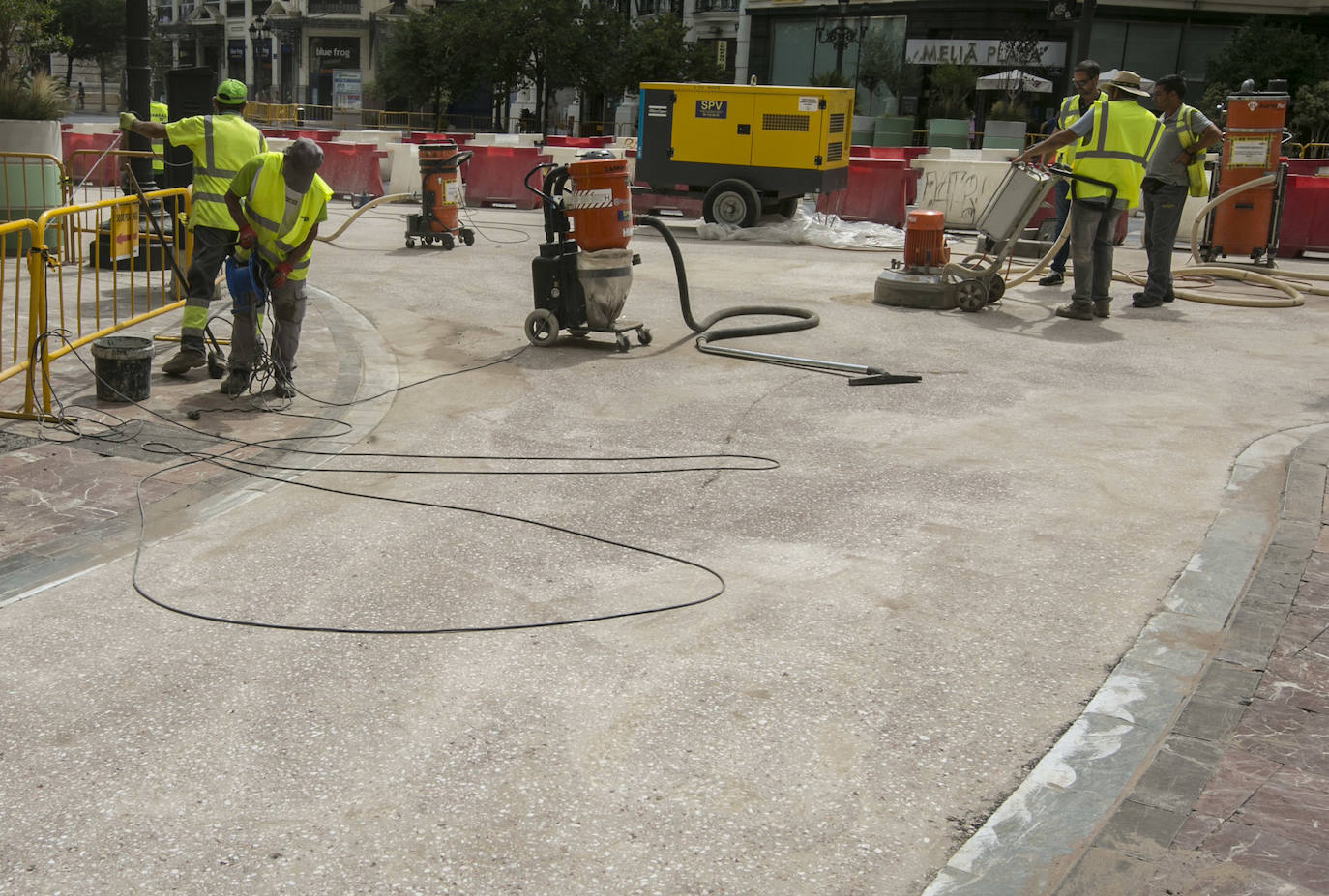 En la zona próxima a la calle Barcelonina, como se observa en la imagen, la contrata de asfaltado ha comenzado ya a aplicar el acabado del nuevo pavimento de la plaza del Ayuntamiento, que quedará de color rojizo para igualarlo con las aceras y distinguir las nuevas zonas peatonales de la parte que quedará abiertas al tráfico. La última capa será una resina antideslizante que además ayudará a fijar el tono con el pulimentado de los áridos mezclados con el aglomerado.