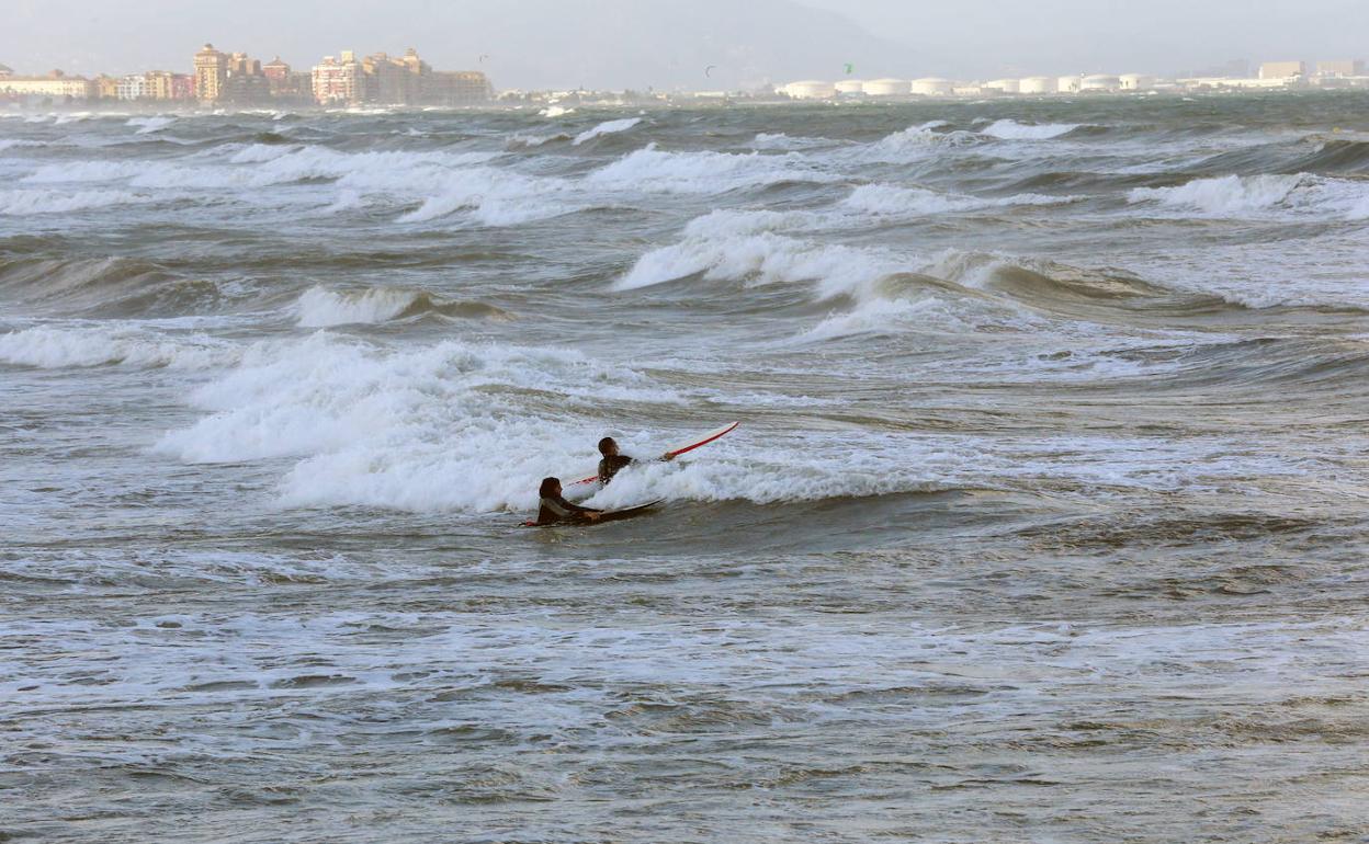 Dos jóvenes practican deporte en la playa del Cabanyal, junto a la Marina. 