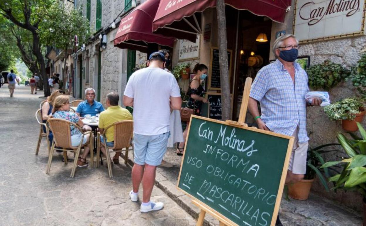 Carteles en una pastelería en Palma de Mallorca informan de la obligatoriedad de mascarillas en todos los espacios públicos.