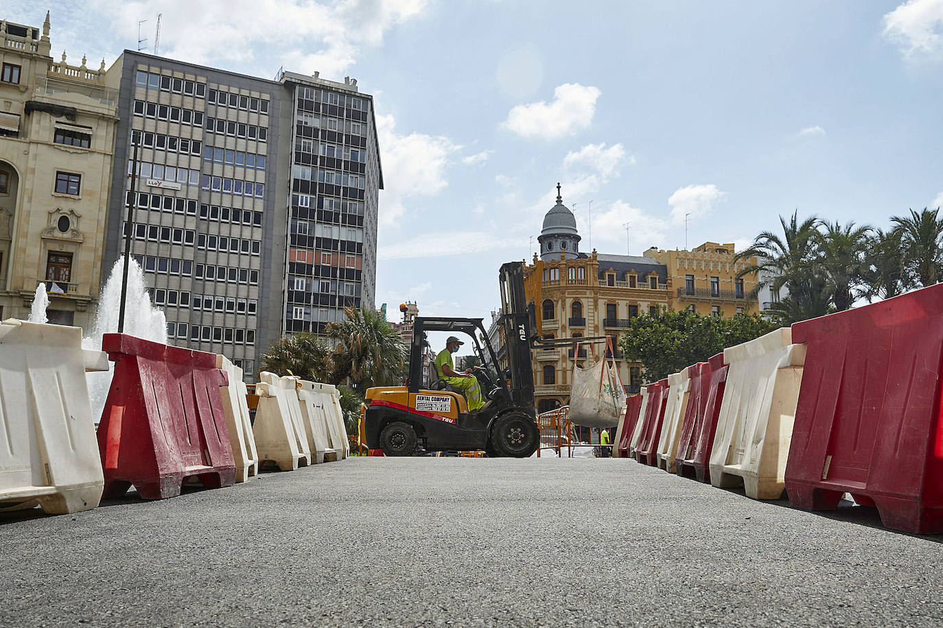 El nuevo asfalto rojizo de la plaza del Ayuntamiento ya está terminado en el tramo frente al teatro Rialto, cerca de la esquina con la calle Barcelonina, por lo que es la imagen más fidedigna de cómo quedará la plaza cuando terminen las obras, que se espera que finalicen en días. 