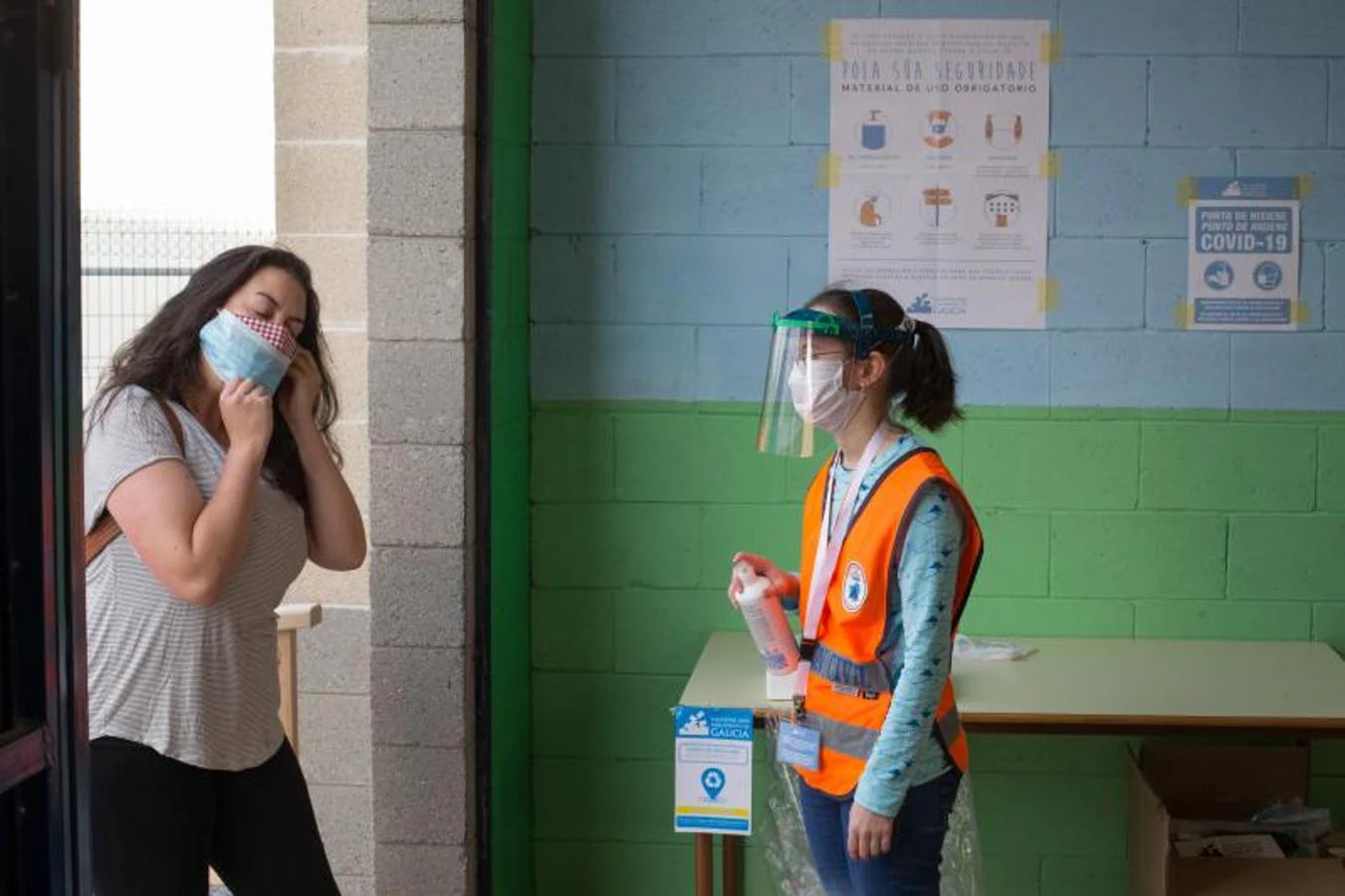 Desinfeccion de manos antes de entrar en el colegio electoral de Burela (Galicia)