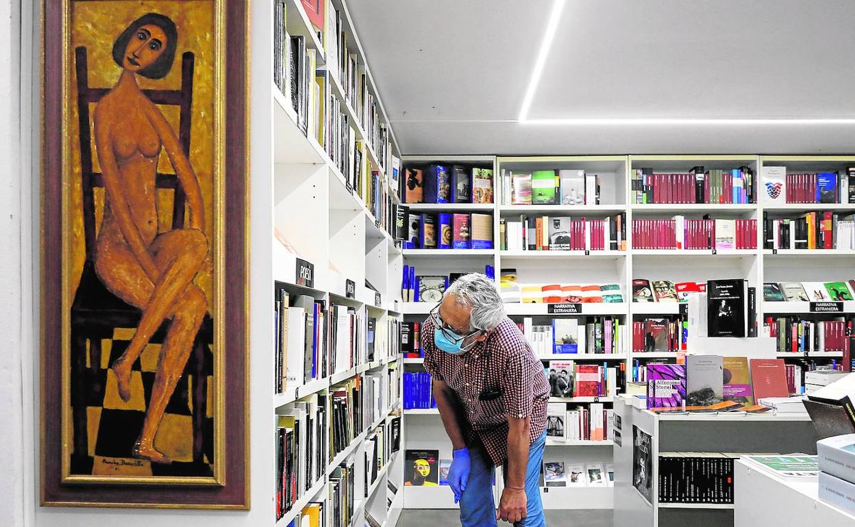 Un hombre consulta los anaqueles de una librería en Valencia. 