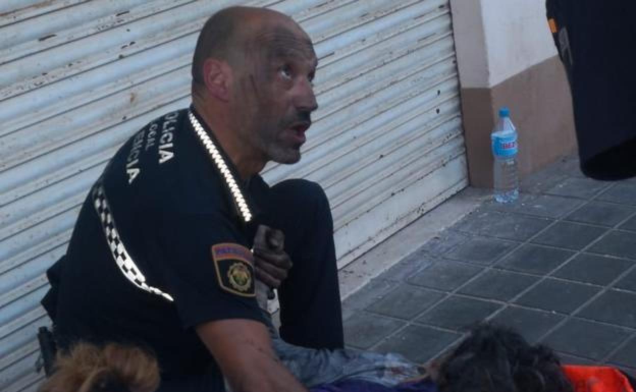 El agente de la Policía Local, el viernes, junto a la mujer a la que salvó. 