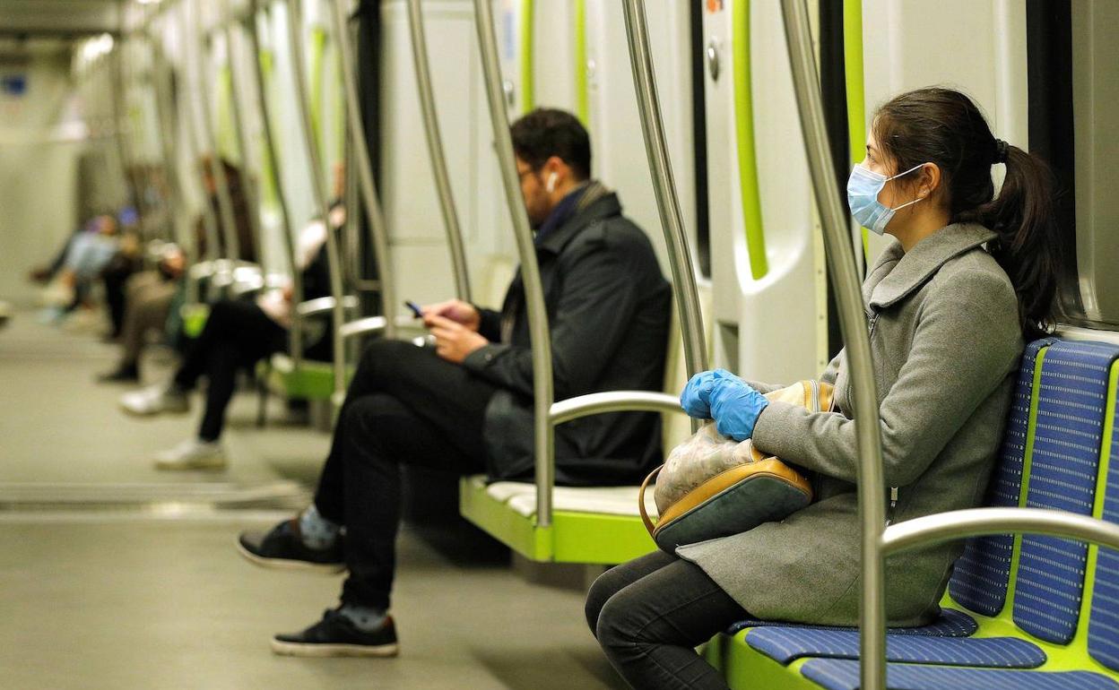 Viajeros con mascarilla en el metro. 