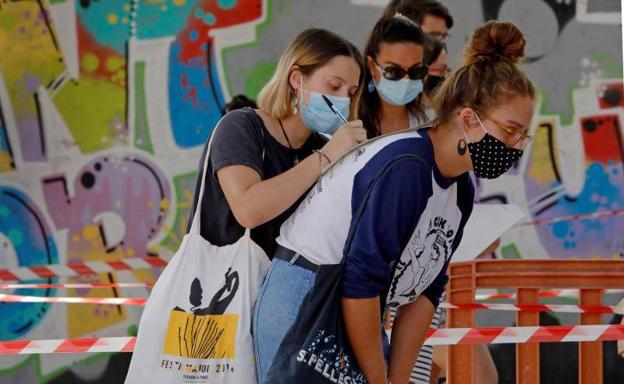 Varias jóvenes guardan cola para hacerse voluntariamente test de covid-19 en Barcelona.