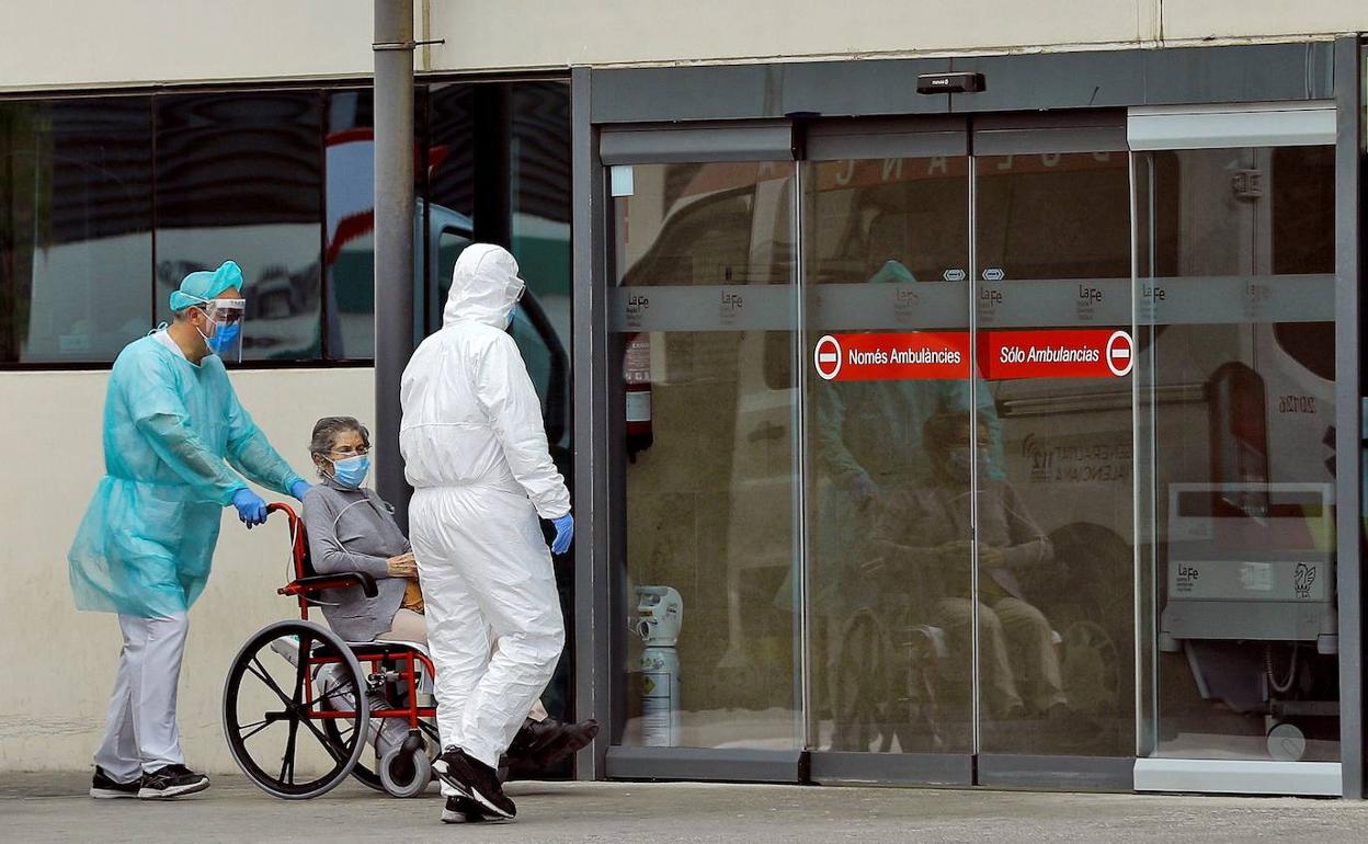 Sanitarios y un paciente, a las puertas del hospital La Fe.