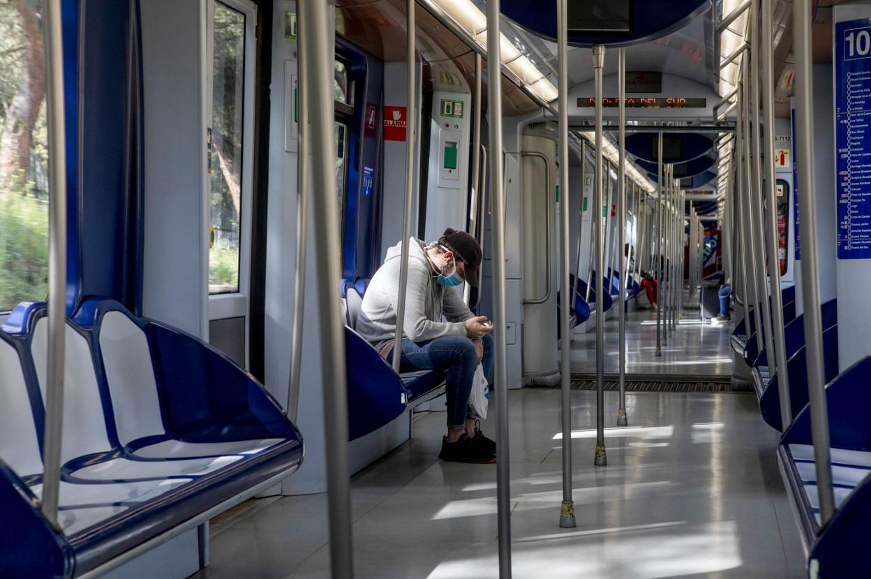 Un joven con mascarilla, en el metro. guillermo Gutierrez