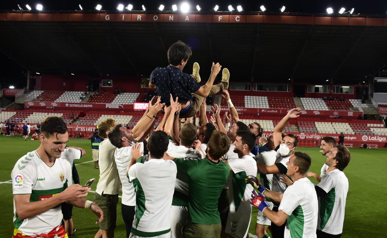 Los jugadores del Elche mantean a Pacheta anoche tras el ascenso en el césped de Montilivi. 