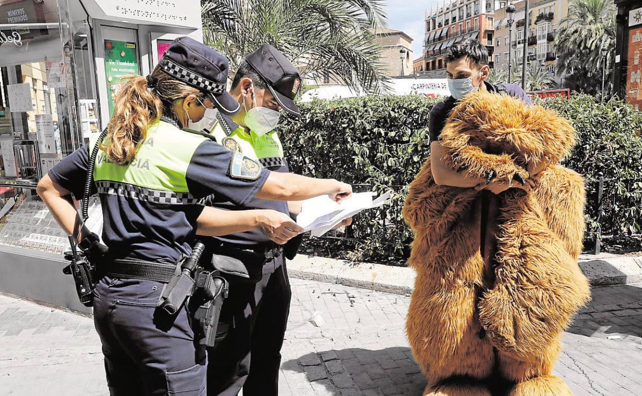 Agentes de la Policía de Valencia informando sobre las medidas para frenar la pandemia. 