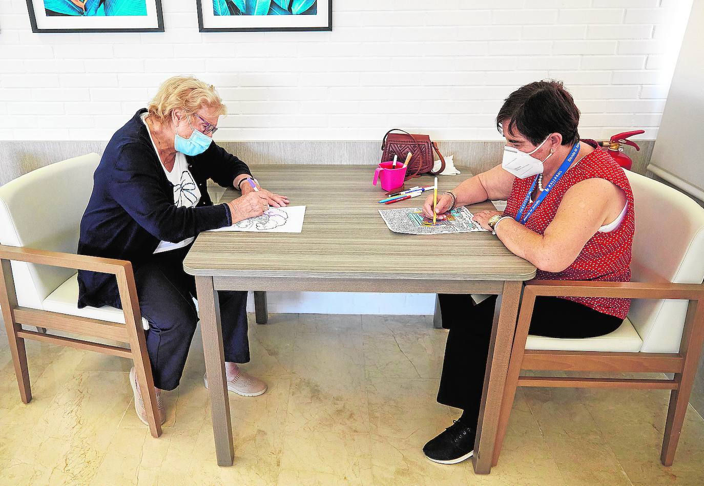 Dos compañeras de grupo de la residencia Ballesol Valterna, en plena actividad de creación artística. 