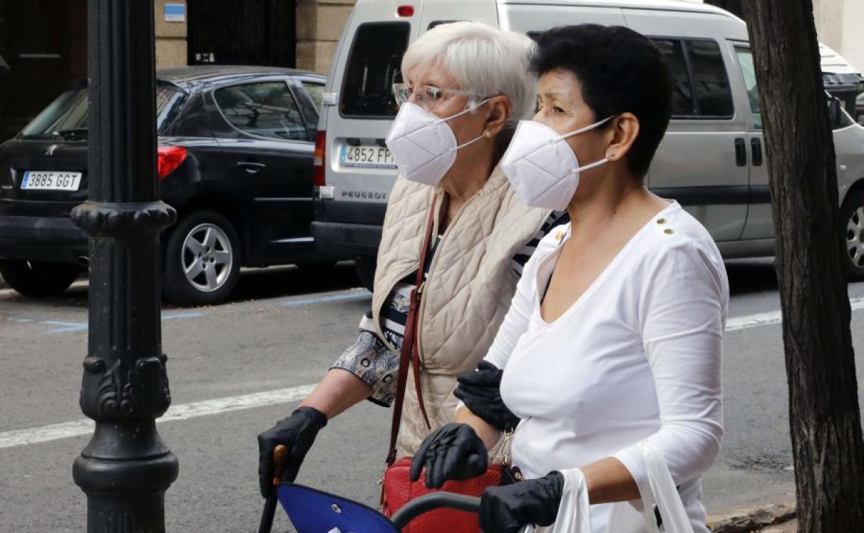 Dos mujeres con mascarilla en una calle de Valencia. 