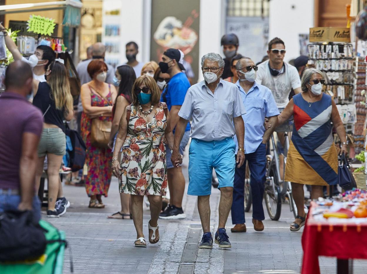 Decenas de personas con la mascarilla obligatoria paseando ayer por el centro de la ciudad de Valencia. iván arlandis