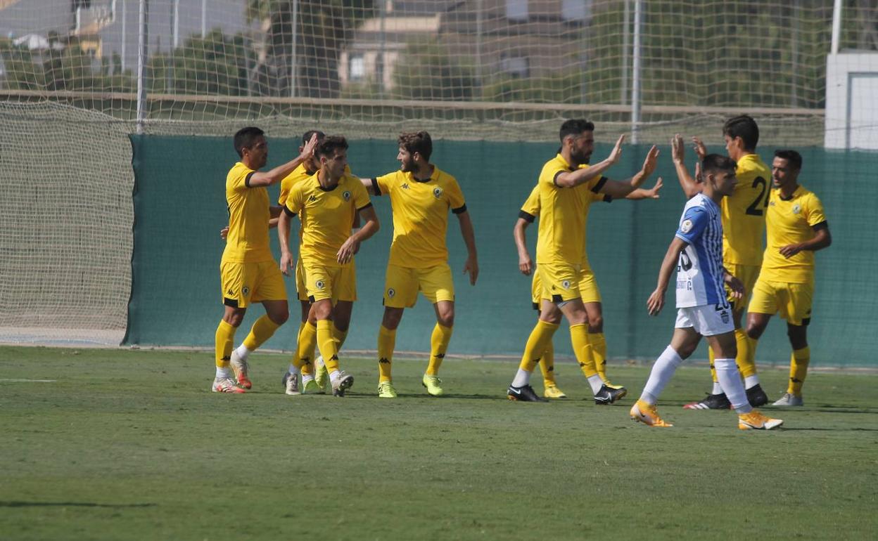 Los jugadores del Hércules, de amarillo, felicitan a Benja después del 2-1 anotado esta mañana en Pinatar. 