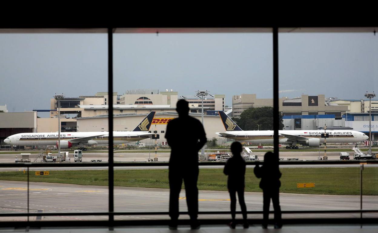 Varias personas, en un aeropuerto internacional. 